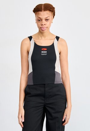 Crni i sivi skraćeni atletski top s Nike logotipom. Ima kontrastne svijetlosive panele i prilagođeni dizajn. Izrađen je od rastezljivog materijala.