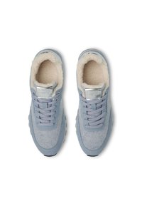 Sneaker azzurro chiaro con tomaia in tessuto simile alla lana, morbido rivestimento crema, lacci grigi e una patch metallica con logo sulla linguetta.