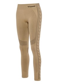 Leggings beige sans couture avec taille côtelée, zones de ventilation perforées et logo hummel noir près de la taille sur fond blanc.