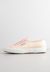 Sneakers in tela glitter rosa con punta tonda, suola in gomma bianca e design con lacci. Presenta un logo Superga sul lato.