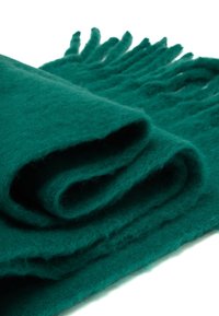 Bufanda de lana color azul verdoso con una textura suave, que presenta bordes con flecos y un aspecto liso y enrollado, resaltando su diseño acogedor y cálido.