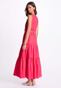 Rosa, ärmelloses Maxikleid mit tailliertem Oberteil, gestuftem Rock und Gürtel. Glatte Textur, knöchellang, mit einer lässigen Silhouette.