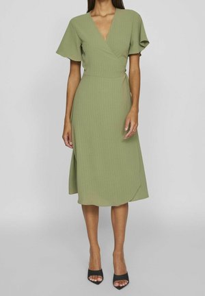 Groene wikkeljurk met korte fladdermouwtjes, een V-halslijn en een knielengte zoom. Gemaakt van textuurstof met een subtiel patroon.