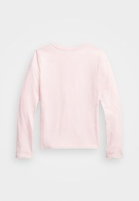 Jasnoróżowa koszula z długim rękawem wykonana z miękkiej bawełny. Prosty design z okrągłym dekoltem i prostym dołem. Gładka faktura, bez wzorów i dodatków.