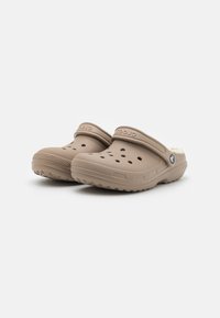 Béžové pracovné clogs vyrobené z ľahkého syntetického materiálu, s ventilačnými otvormi, kožúškovým podšívkou a štruktúrovanou podrážkou pre lepšiu priľnavosť.