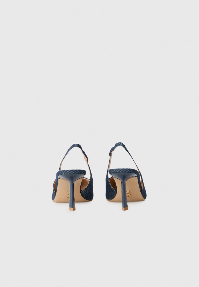 Chaussures à talons hauts bleu foncé avec un design à talon ouvert, présentant une tige en tissu texturé, des côtés ouverts et un talon fin. Détail d'accent doré au niveau du talon.