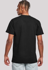 Black cotton T-shirt with short sleeves, featuring a round neckline. The back is plain with no visible logos or patterns.