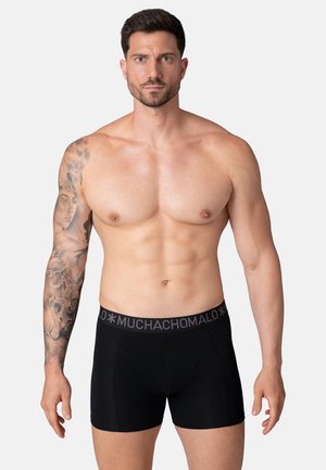 Zwarte boxershorts van zacht materiaal, met een brede elastische tailleband met een grijs logo. Het ontwerp prioriteert comfort en pasvorm.