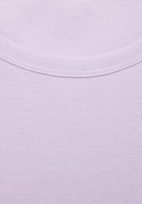 Lilla kortærmet t-shirt i blødt, struktureret stof med et ribbet mønster og rund halsudskæring.