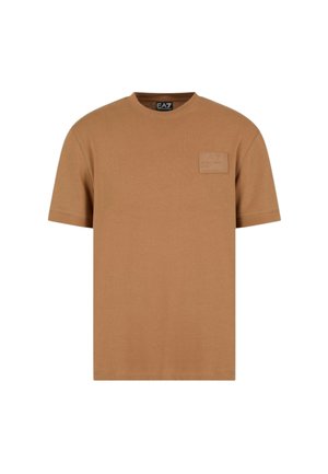 T-shirt in cotone marrone con maniche corte, collo rotondo e logo a patch sulla parte sinistra del petto. Texture liscia, design semplice.