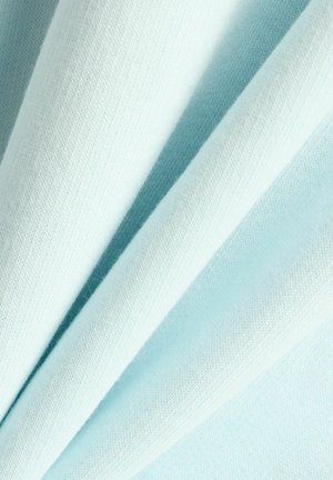 Tessuto blu chiaro con una superficie liscia, che presenta molteplici pieghe e un motivo a maglia che mostra profondità e sottili variazioni di colore.