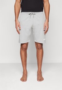 Lichtgrijze katoenen shorts met een elastische tailleband en trekkoord. Voorzien van zijzakken en een klein wit logo op de linker onderbeen.