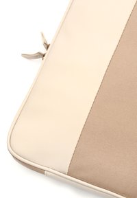Beige laptop sleeve med en glat mat overflade på den ene side og et struktureret stof på den anden, med kontraststing og en lynlås.