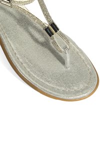 Zilveren glitter flip-flops met decoratieve banden, transparante teenpost en rubberen zool. Getextureerde voetbed en metalen hardware accenten.