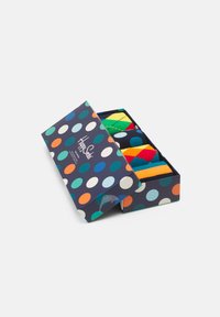 Boîte cadeau de chaussettes colorées avec un motif à pois sur fond marine, contenant plusieurs paires de chaussettes à motifs de différentes couleurs.