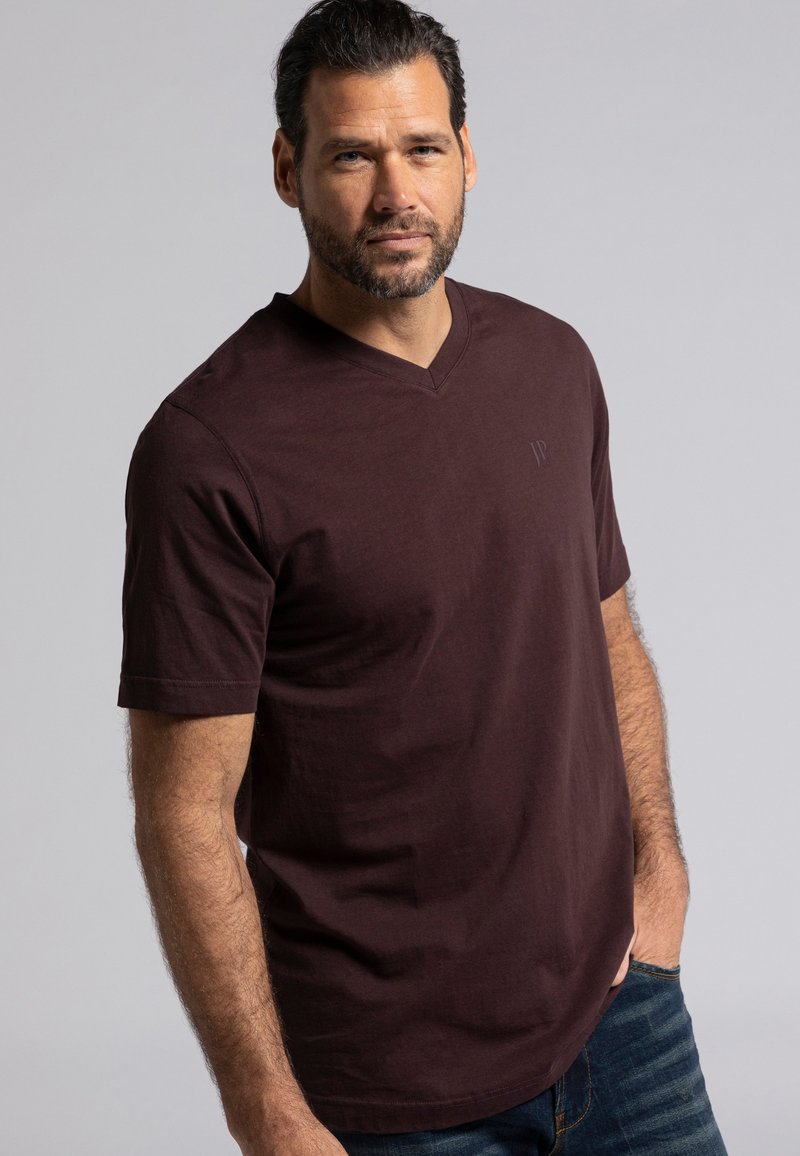 Mørkerød v-hals t-shirt i let materiale med korte ærmer, der har et diskret logo på brystet og en afslappet pasform.
