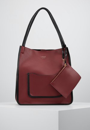 Red leather tote bag with black trim, featuring a front pocket and a detachable matching pouch, smooth texture and open top design.