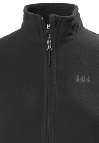 Chaqueta de forro polar negra con cuello alto, cremallera completa y un sutil logotipo en la parte frontal. Textura suave y diseño clásico.