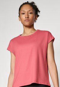 Short-sleeve, pink t-shirt with a rounded neckline and relaxed fit, made from soft fabric. Minimalistic design with no visible patterns.