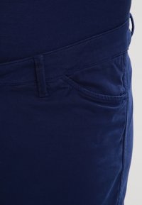 Granatowe bawełniane spodnie o gładkiej strukturze, z przednią kieszenią i szlufkami na pasek, w dopasowanym kroju.