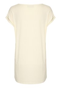 T-shirt beige clair, coupe ample avec des manches courtes roulées et un col rond. Texture douce, design épuré sans motifs ni accents.
