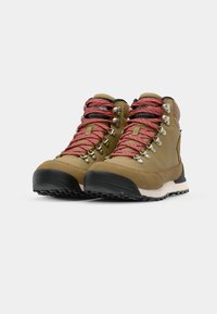 Bottes de randonnée brunes avec des lacets rouge et blanc à pois, œillets en métal, semelles en caoutchouc et embouts renforcés ; conception légère et durable.