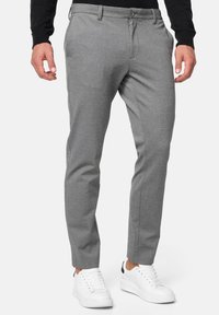 Grå skreddersydde bukser laget av teksturert stoff, med knappedetaljer i midjen, sidelommer og slim fit, kombinert med hvite sneakers.