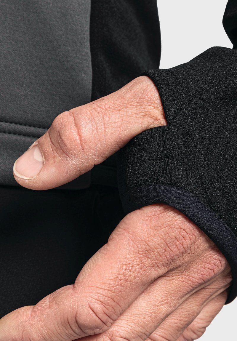 Nahaufnahme eines schwarzen Stoffärmels mit strukturierter Oberfläche, der ein Daumenloch und eine glatte Bündchenkante aufweist und ein komfortorientiertes Design zeigt.
