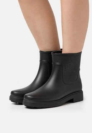 Black rubber ankle boots with a textured black panel, flat sole, and rounded toe. Simple design with no visible hardware or embellishments.