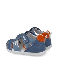 Sandalias de cuero azul con recortes, correa ajustable y acentos naranjas. Suela de goma duradera y interior blanco con detalles estampados.