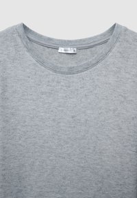T-shirt à col rond gris en tissu doux ; présente une surface texturée avec un design simple et épuré et une étiquette cousue dans l'encolure.