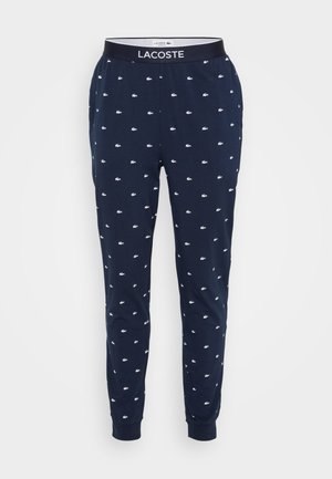 Pantalons lounge bleu marine en coton, dotés d'un motif de logo blanc répété, d'une taille élastique avec étiquette de marque et de poignets ajustés.