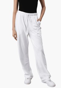 Weiße, leichte, locker sitzende Hose mit einem elastischen Bund und Kordelzug; ausgestattet mit Seitentaschen und glatter Textur.