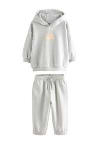 Hall halliga kapuutsiga dressipluus "COOL VIBES" trükiga ja hallide elastse vöökohaga spordipükstega. Pehme, sile kangas; lõdvestunud istuvus; soonikkoes mansetid.