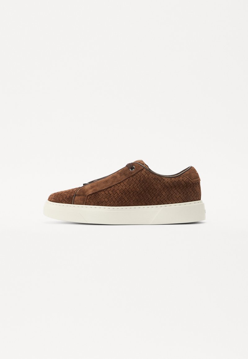 Brown suede sneaker with a woven texture, white rubber sole, and minimalistic design. Features subtle stitching and rounded toe shape.