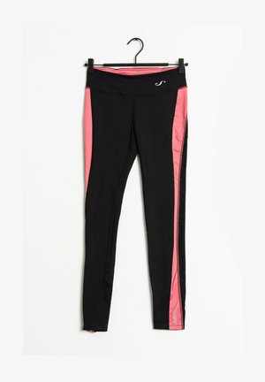 Czarne sportowe legginsy z różowymi panelami po bokach i małym białym logo na gumce, zawieszone na czarnym wieszaku na białym tle.