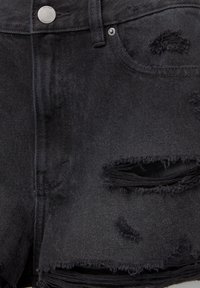 Shorts en denim noir avec bords effilochés et plusieurs déchirures usées près de la poche avant et de la cuisse.