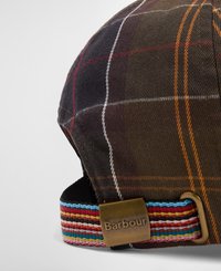 Boné xadrez castanho com riscas laranja, brancas e vermelhas, apresentando uma faixa colorida riscada na parte de trás e um detalhe metálico com o logótipo da Barbour.