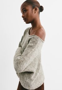 Strickpullover in hellem Beige mit einem lockeren, schulterfreien Design. Strukturierter Stoff mit einer gemütlichen, oversize Passform. Keine auffälligen Muster oder Hardware.