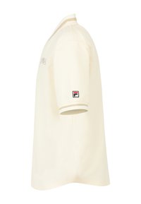 Polo shirt color crema con un tessuto testurizzato, caratterizzato da un colletto e polsini a coste con una striscia a contrasto. Logo Fila sul petto.