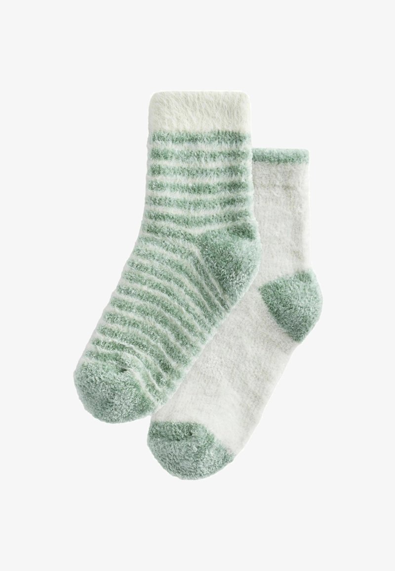 Pár mäkkých ponožiek: jedny mentolovo zelené s bielymi pruhmi, druhé úplne biele s mentolovo zelenými akcentmi na päte a špičke. Plyšová textúra.