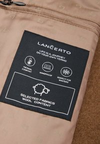 Brązowy materiał o fakturowej powierzchni z czarną metką oznaczoną "LANÇERTO". Symbole wskazują na komfort termiczny, wiatroszczelność i użycie zimowe.