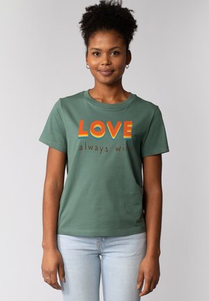 Groene katoenen t-shirt met de tekst "LOVE" in oranje en geel, met de zin "always wins" in bruin, korte mouwen en een ronde hals.