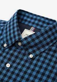 Niebieska i granatowa kraciasta koszula z kołnierzykiem na guziki, białymi guzikami oraz kontrastującym, wzorzystym wewnętrznym kołnierzykiem. Widoczna metka.
