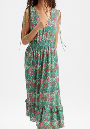 Sleeveless green floral dress with pink, white, and red flowers, V-neck, gathered waist, ruffled hem, and shoulder tie straps.