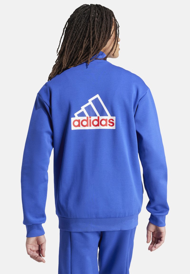Blauwe crewneck sweatshirt met een rood-wit adidas-logo op de achterkant, ribgebreide boorden en een casual pasvorm. Gemaakt van zacht textielmateriaal.