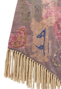 Tkanina tkana z mieszanką różowego, brązowego i kremowego koloru, z niebieskimi, różowymi i żółtymi haftami oraz beżowymi frędzlami wzdłuż krawędzi.