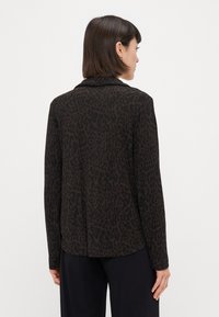 Blazer de padrão de leopardo em castanho escuro e preto, com colarinho em lapela, mangas longas e um tecido suave e texturizado, com um corte descontraído.