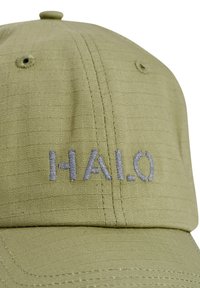 Oliwkowo-zielona czapka z teksturowanej tkaniny, z wyszywanym napisem "HALO" w jasnoszarym kolorze. Widoczne przeszycia i usztywniony daszek.