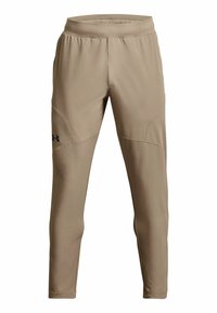 Beiga träningsbyxor med elastisk midja, avsmalnande ben och sydda detaljer. Har svart logotyp på vänster lår. Slät textur.